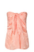Peach strapless silk jacquard blouse with a front tie knot and subtle leaf pattern.