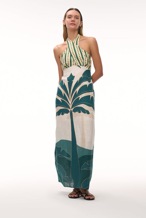 Woman wearing a linen halter midi dress with green striped bodice and aquamarine palm tree skirt.